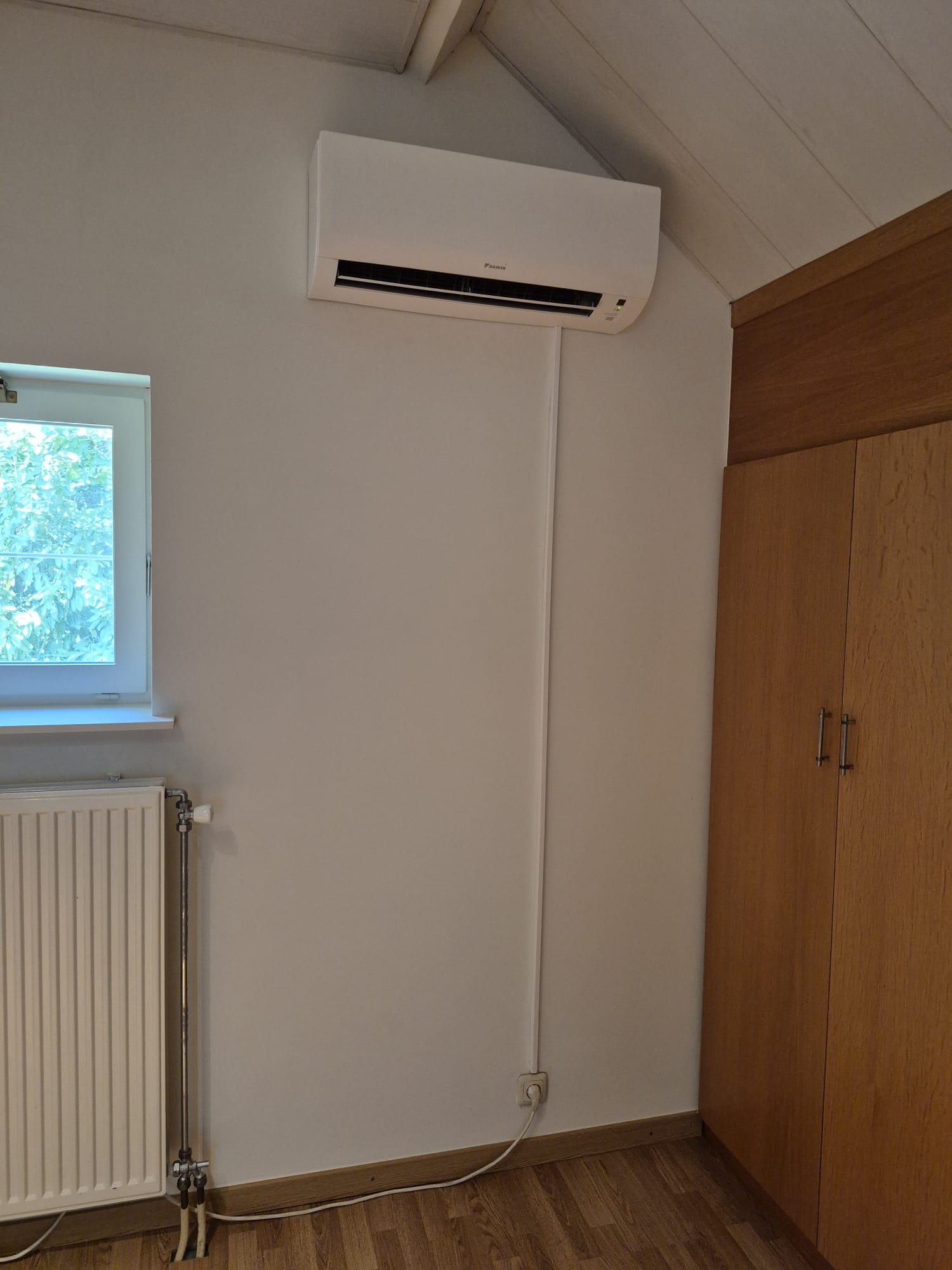 Dezelfde zoldermuur met een geplaatste Daikin-airco